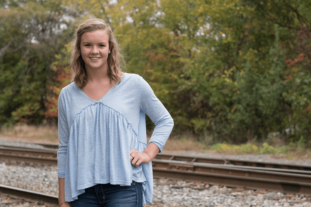Female patient standing by railroad tracks