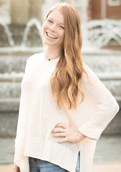 Invisalign Teen patient standing in front of fountain