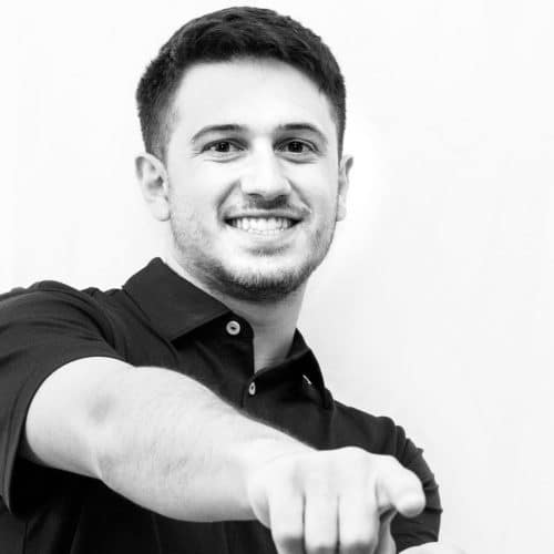 A black and white photo of a man pointing at the camera.