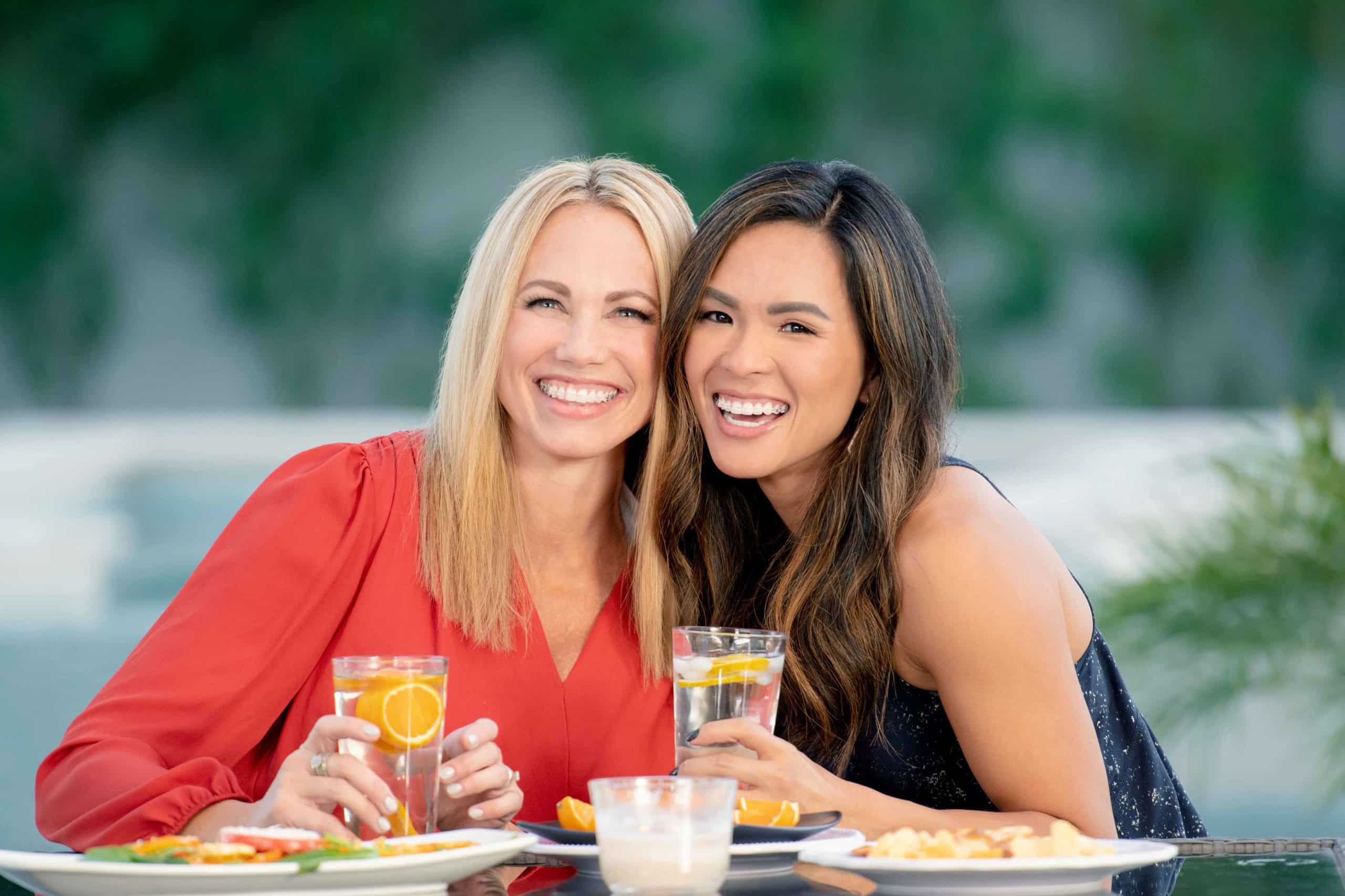 Two women sitting together and smiling at brunch.
