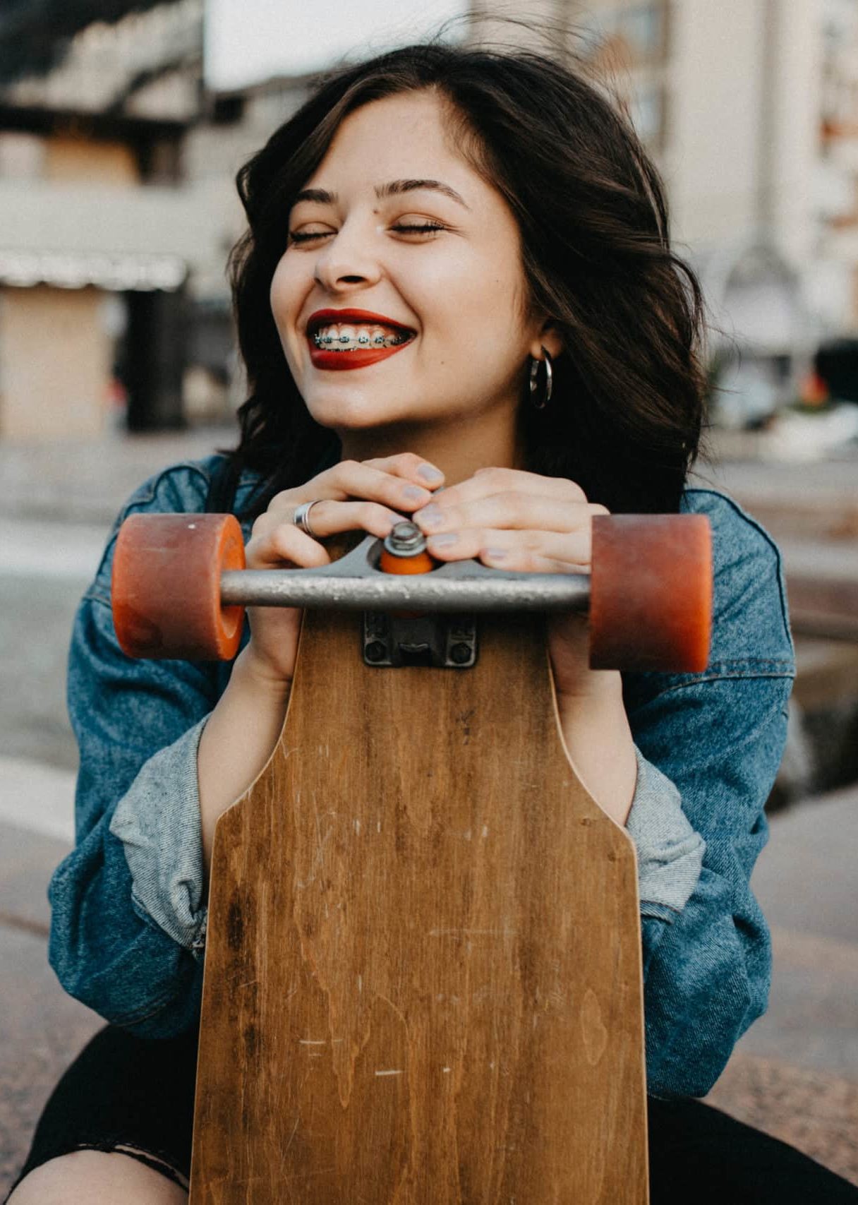 Beautiful Urban young female in the city with her longboard.